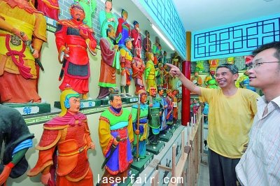 襄陽一老人在自辦的“三國人物泥塑館”為參觀者介紹自己的泥塑作品。